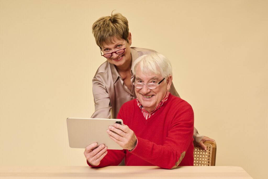 Blije man en vrouw met leesbrillen op sterkte lezen op een Ipad